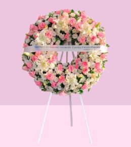 corona funebre rosa y blanca con rosas y liliums sobre pedestal