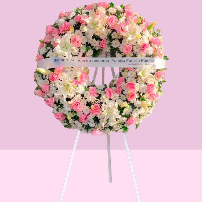 corona funebre rosa y blanca con rosas y liliums sobre pedestal